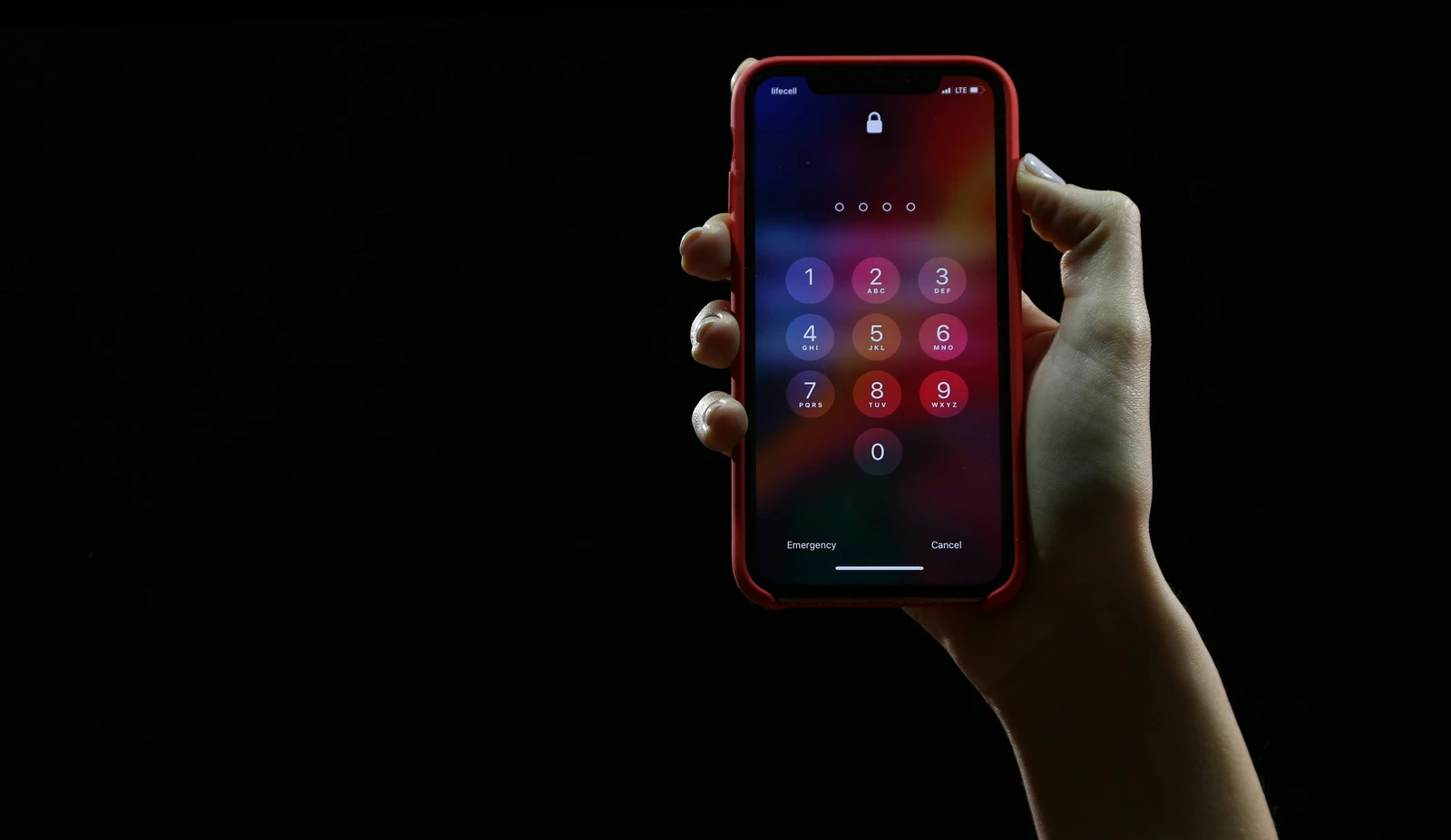 Dłoń trzymająca smartfon z ekranem blokady zabezpieczonym kodem PIN